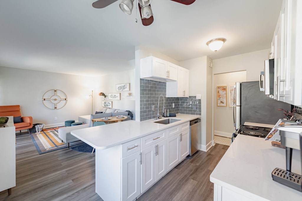 a kitchen with a white counter top and a stainless steel refrigerator