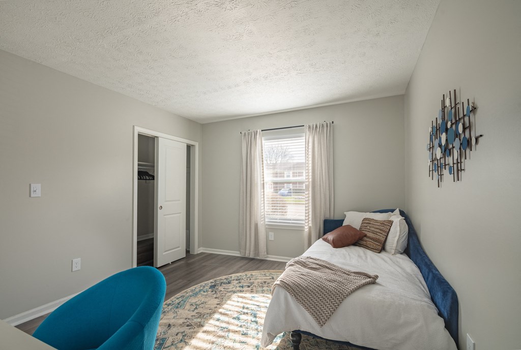 a bedroom with a bed and a chair in a 555 waverly unit