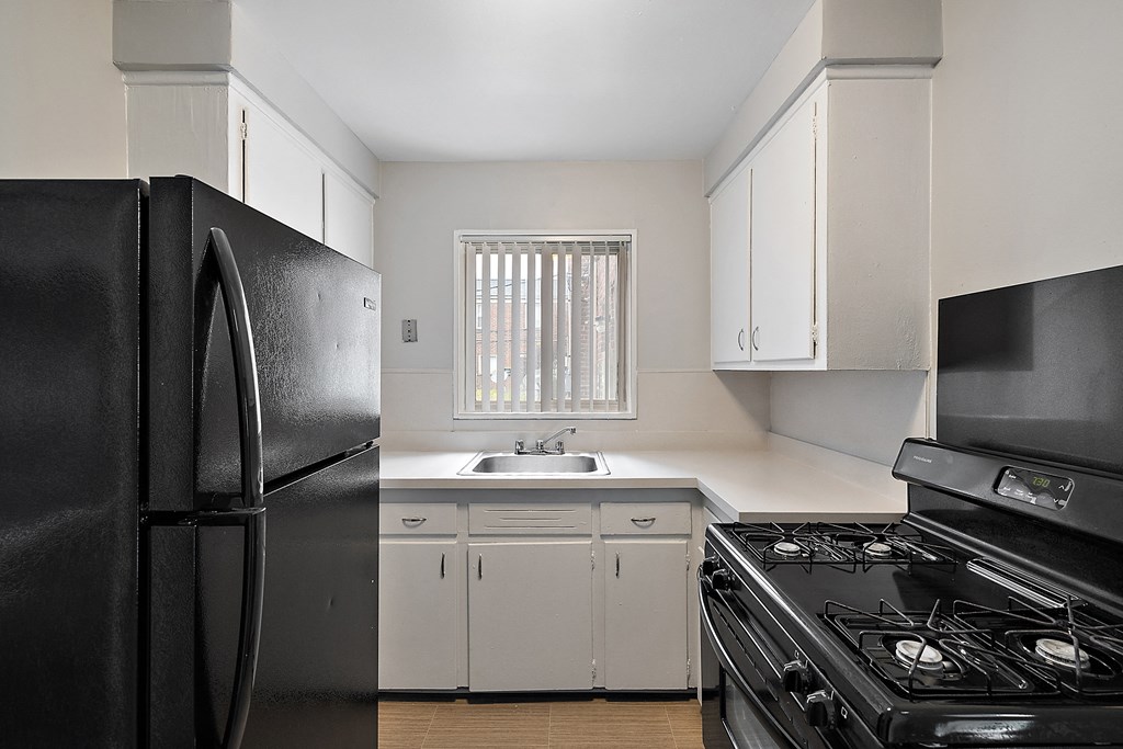 a kitchen with white cabinets and black appliances