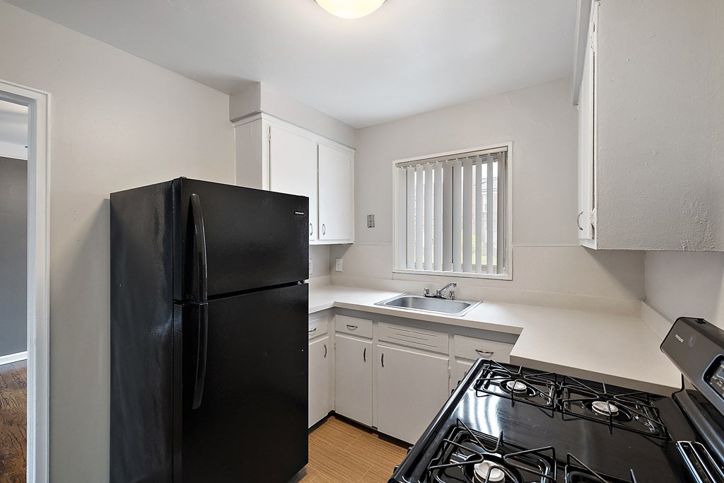 a kitchen with white cabinets and black appliances