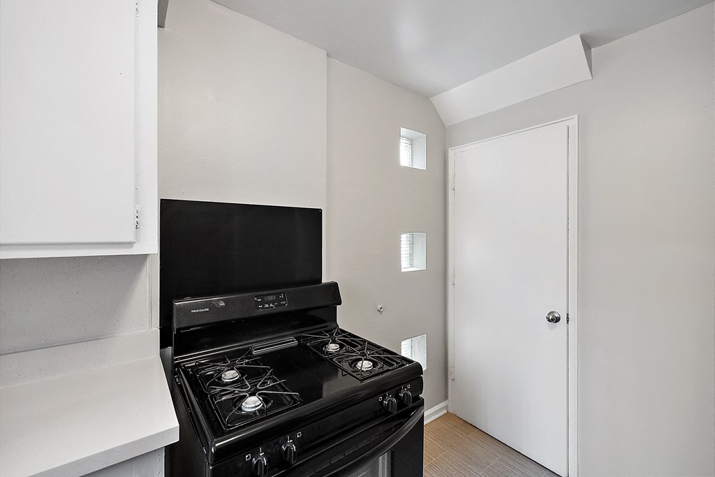 a kitchen with a stove top oven next to a doorway