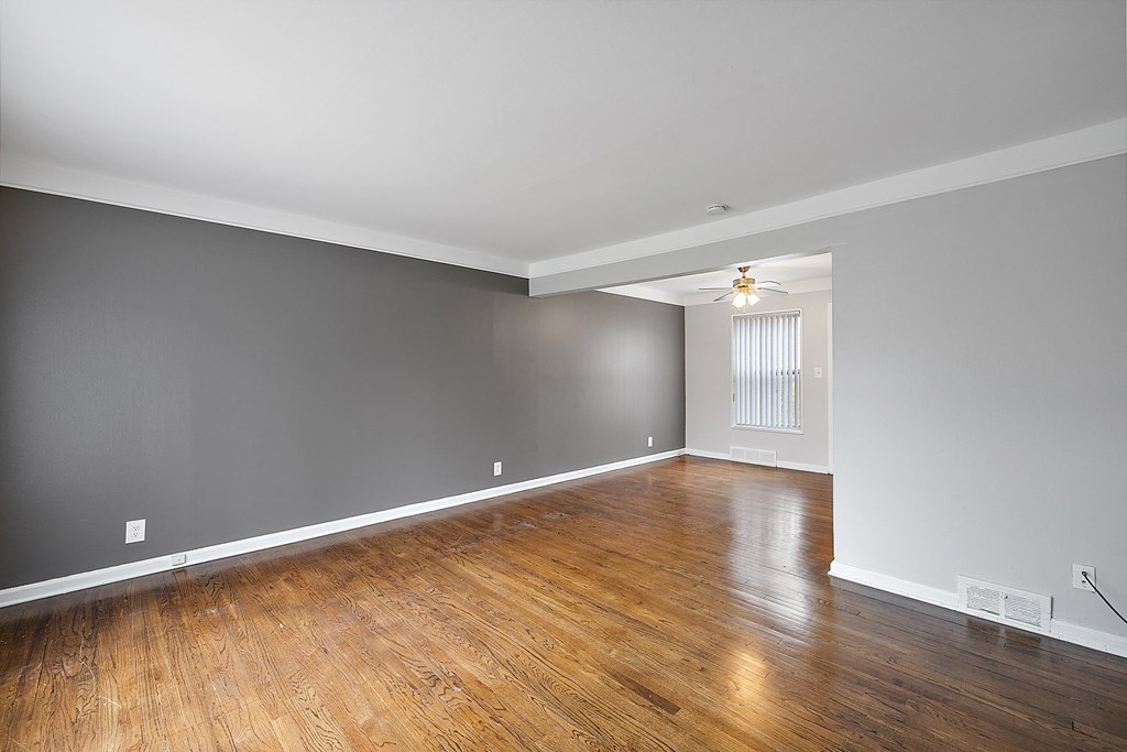 a bedroom with gray walls and hardwood floors