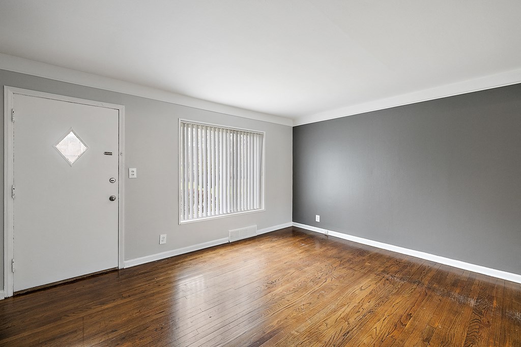 a bedroom with gray walls and hardwood floors