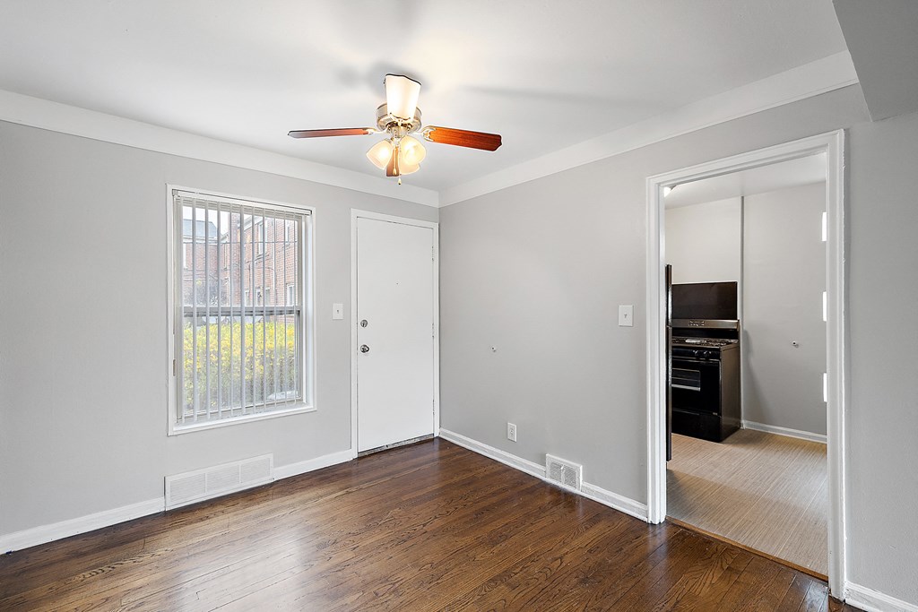 a bedroom with hardwood floors and a ceiling fan