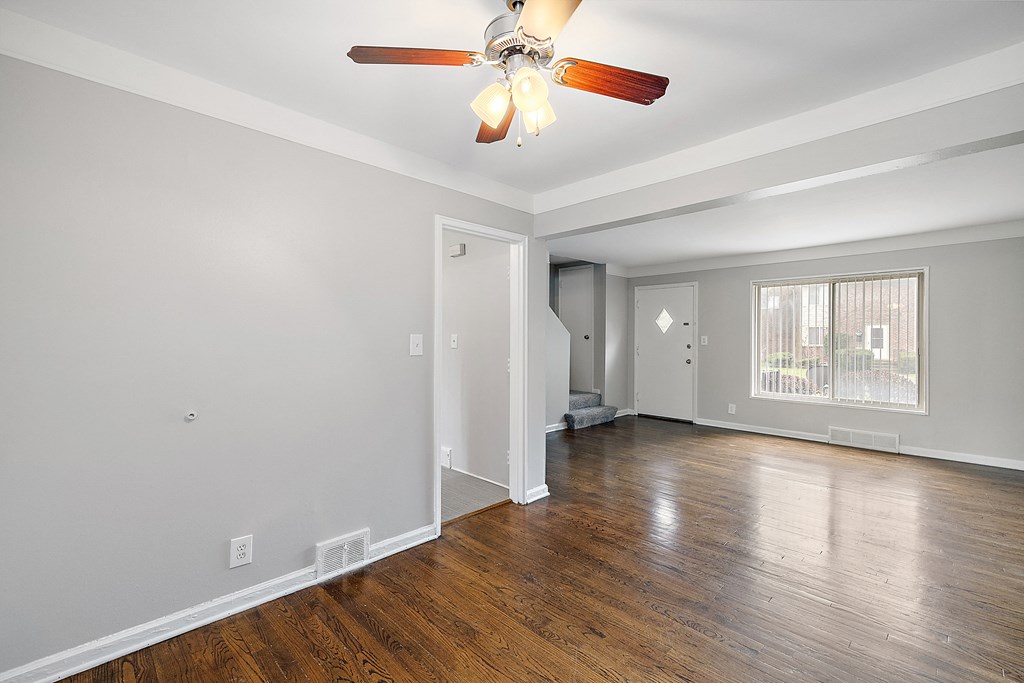 a bedroom with hardwood floors and a ceiling fan
