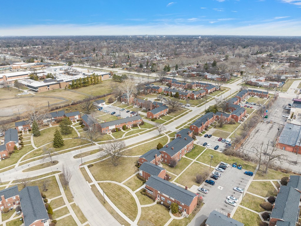 an aerial view of a neighborhood of houses with trees and grass on the ground
