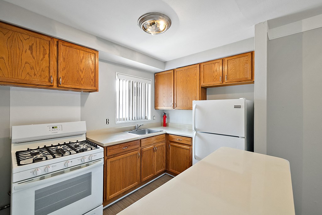 a kitchen with white appliances and wooden cabinets
