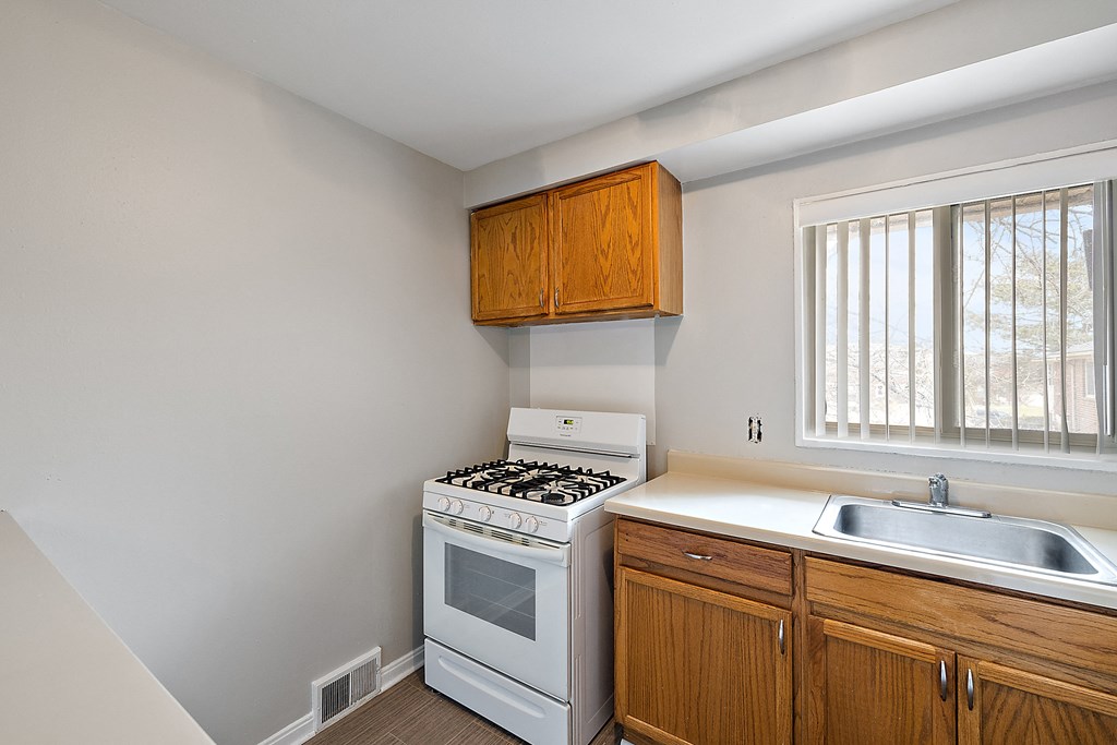 a kitchen with white appliances and wooden cabinets