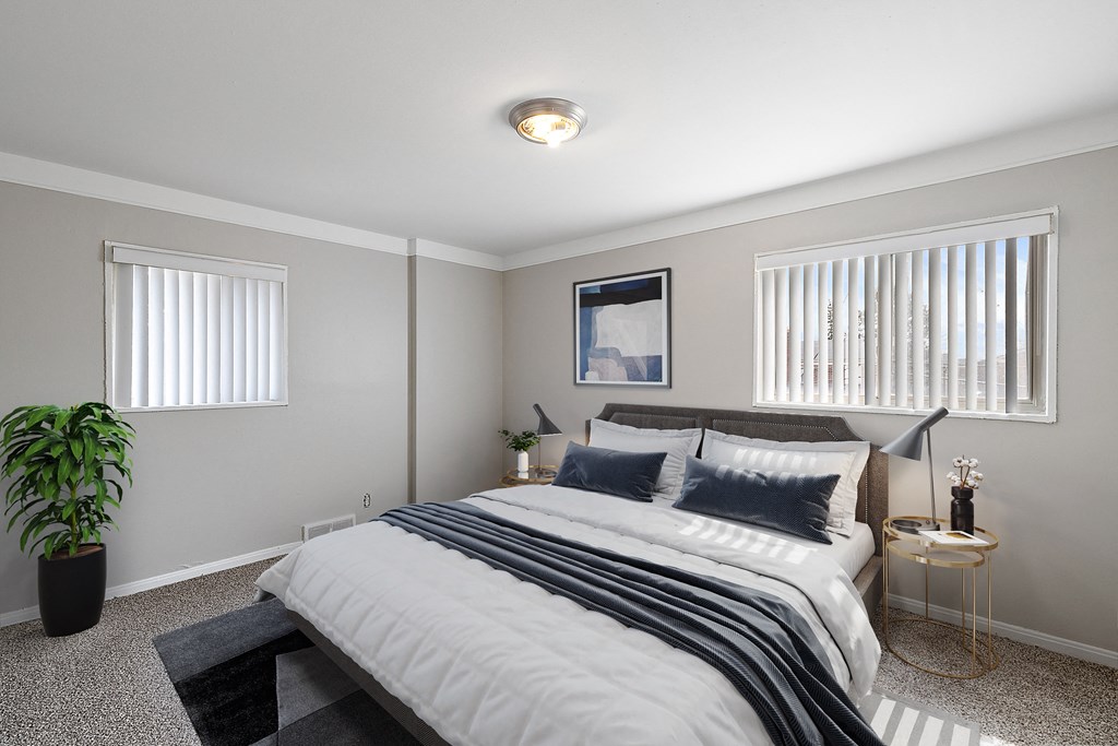 a bedroom with a large bed and two windows