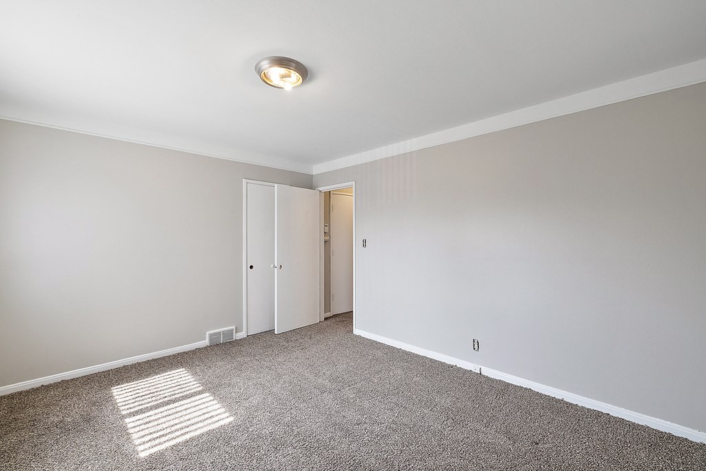a bedroom with grey walls and a carpet