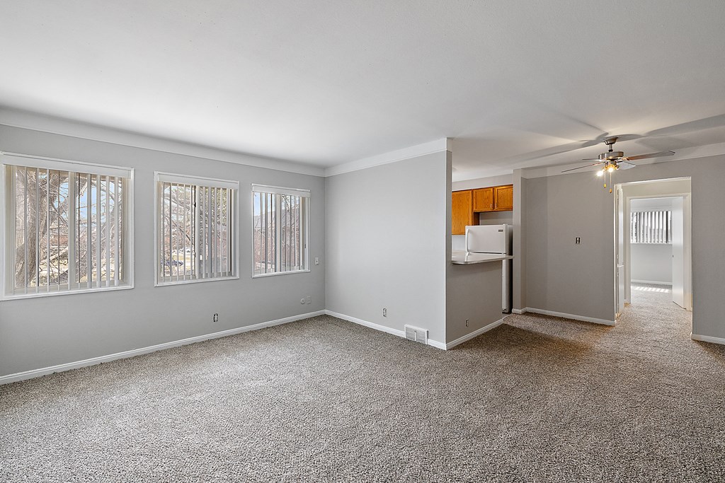 a bedroom with a ceiling fan and three windows