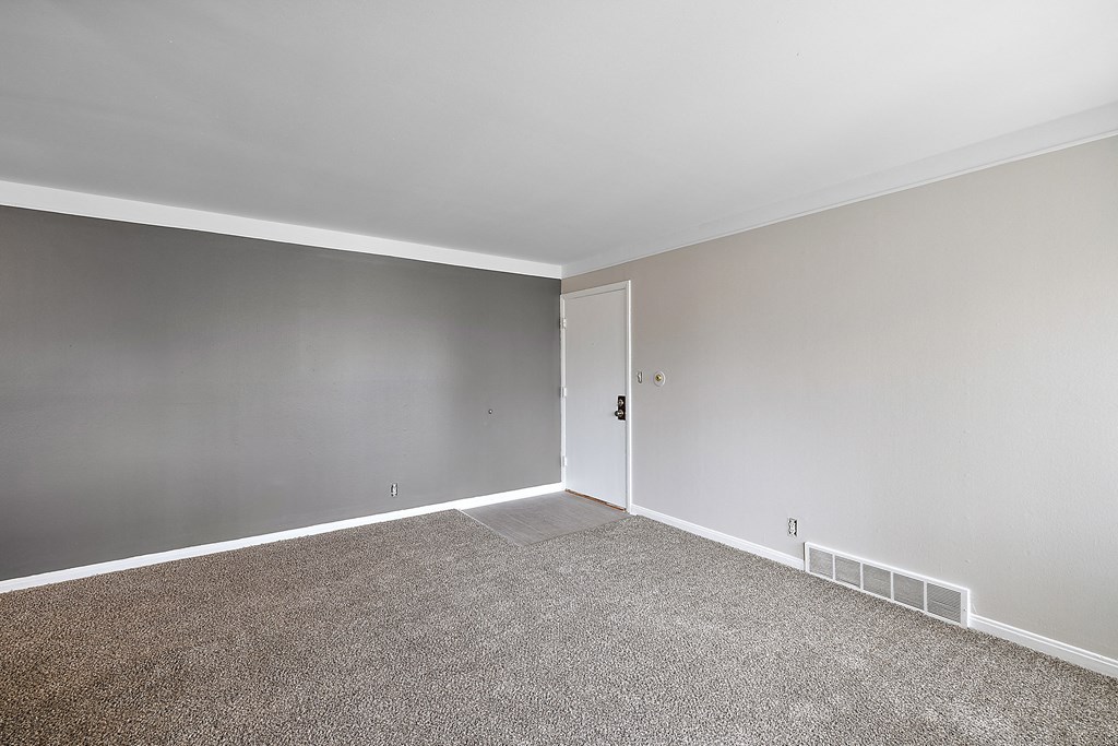 a bedroom with grey walls and a carpet