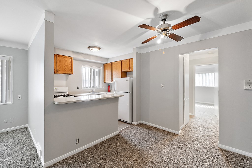 a kitchen with wood cabinets and a ceiling fan
