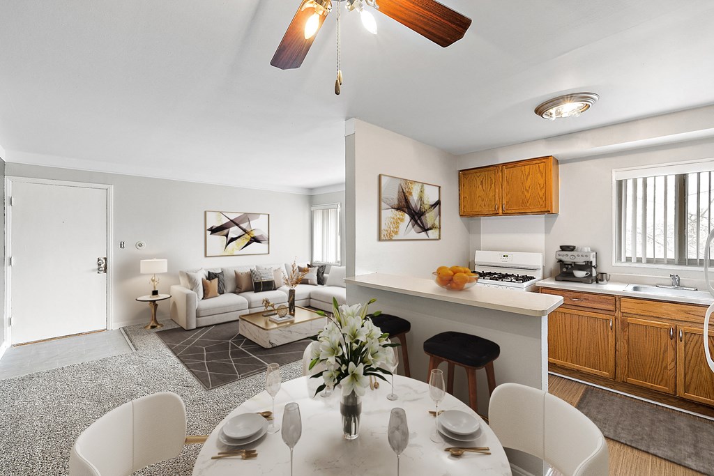 a kitchen and living room with a white table and chairs