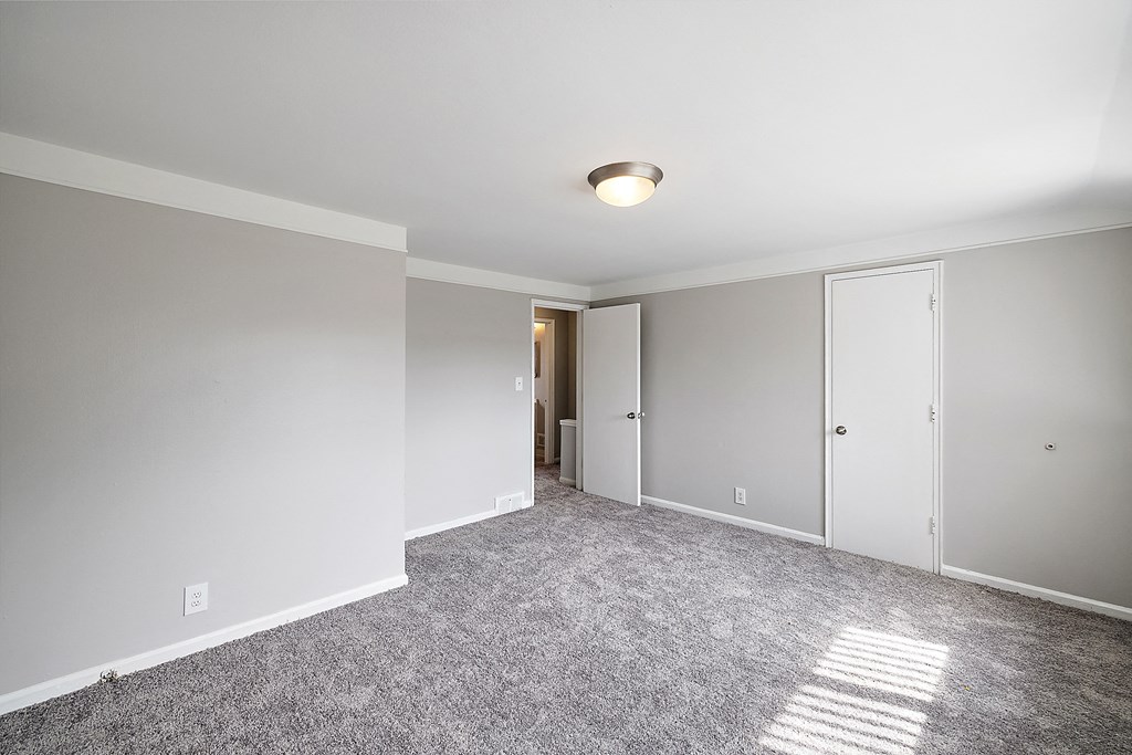 a bedroom with grey carpet and white walls