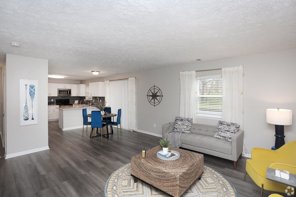 A living room with a grey couch, a yellow chair, and a coffee table.