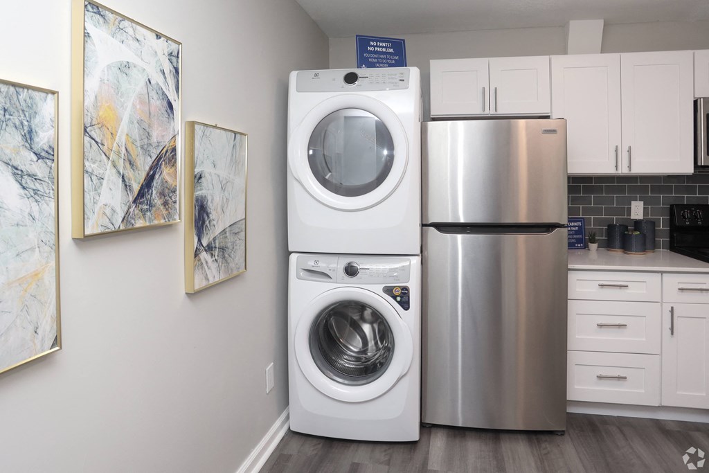 A modern kitchen with a washer and dryer stacked on top of each other.