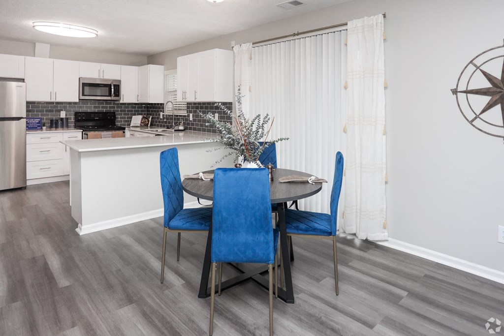A kitchen with a table and chairs.