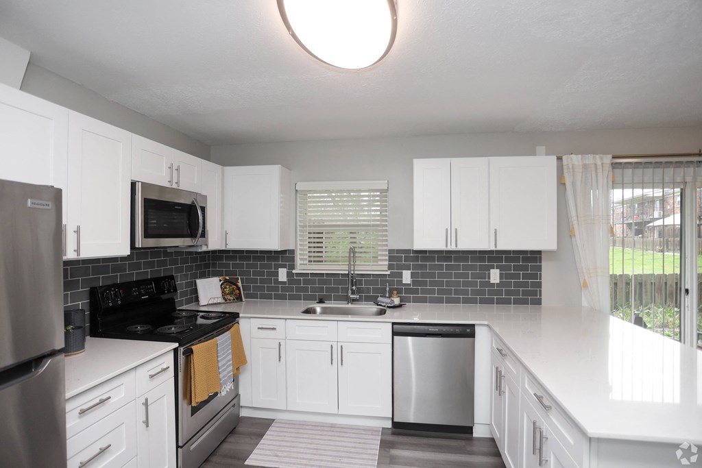 A kitchen with white cabinets and a black stove top.
