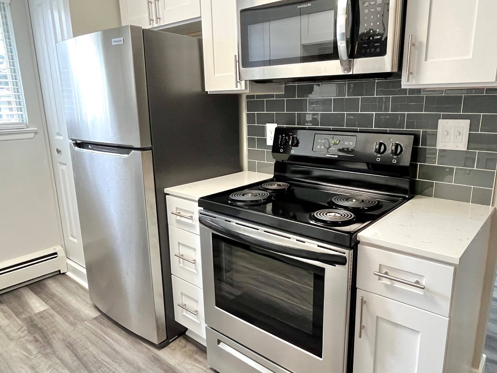 a kitchen with white cabinets and stainless steel appliances