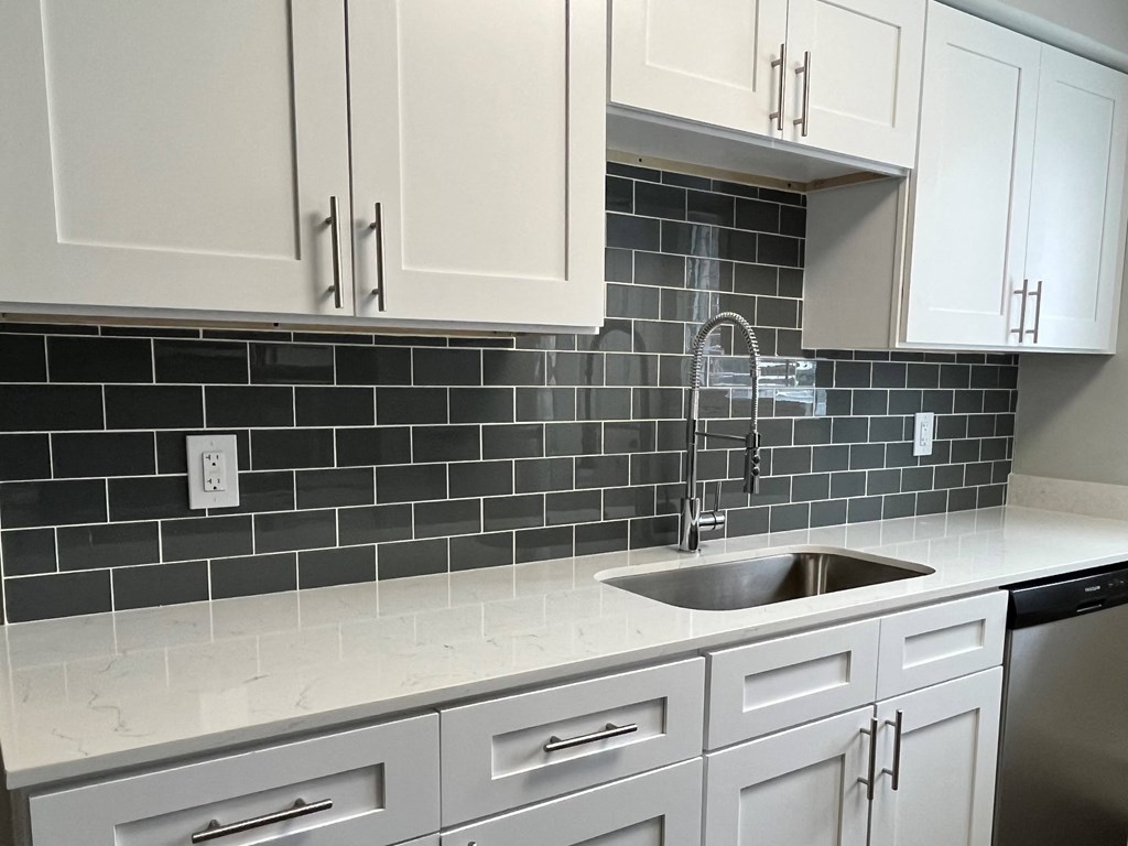 a kitchen with white cabinets and a sink