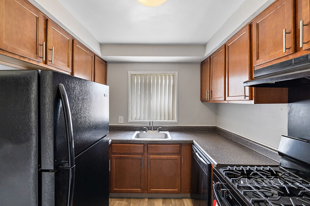 a kitchen with black appliances and wood cabinets