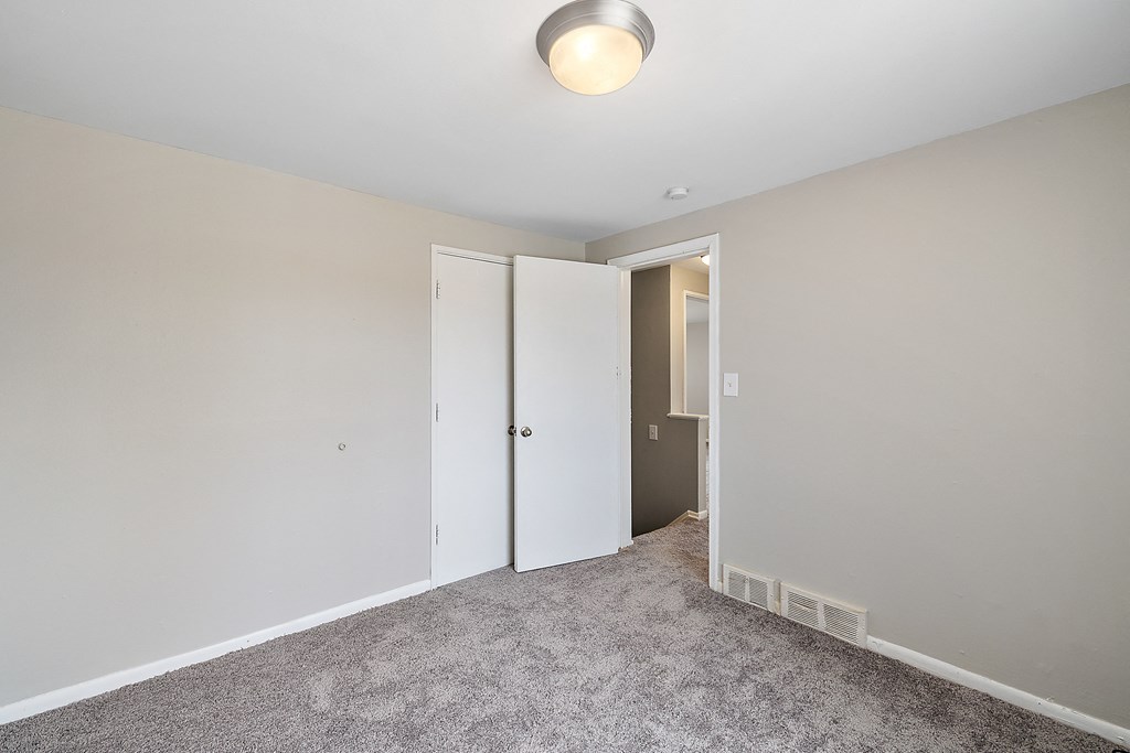 a bedroom with grey carpet and white walls