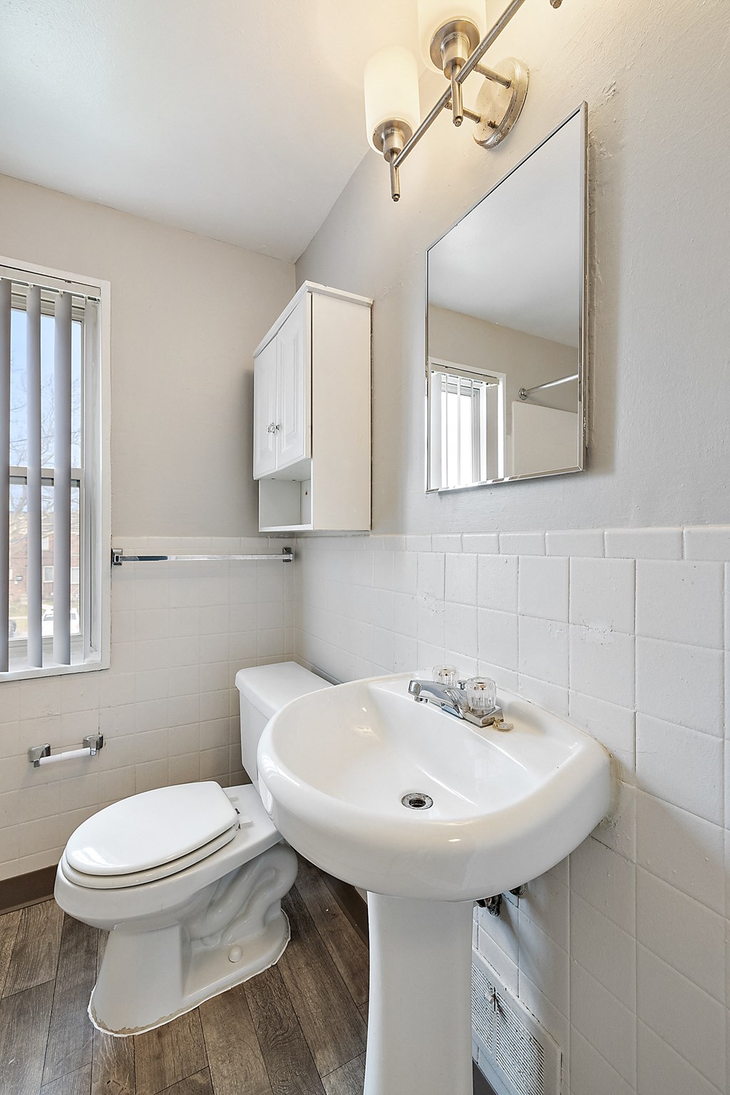 a bathroom with a toilet sink and mirror