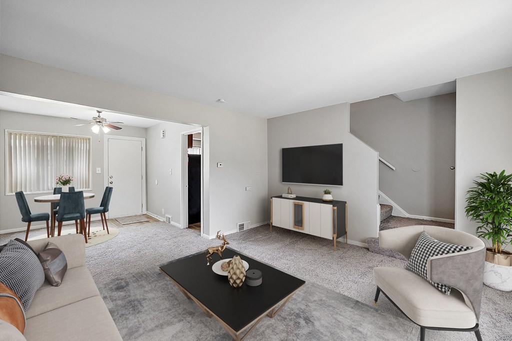 a living room and dining room with a large tv on the wall