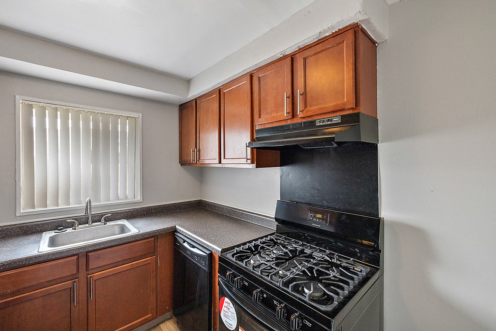 a kitchen with wood cabinets and black appliances