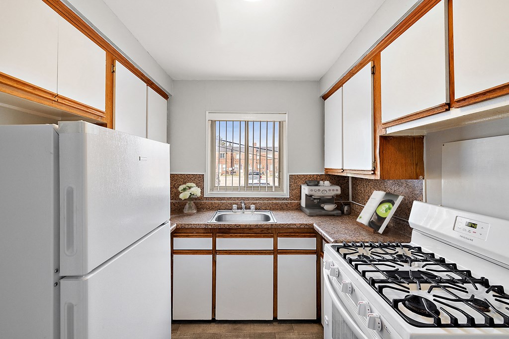 a kitchen with white cabinets and a white stove top oven