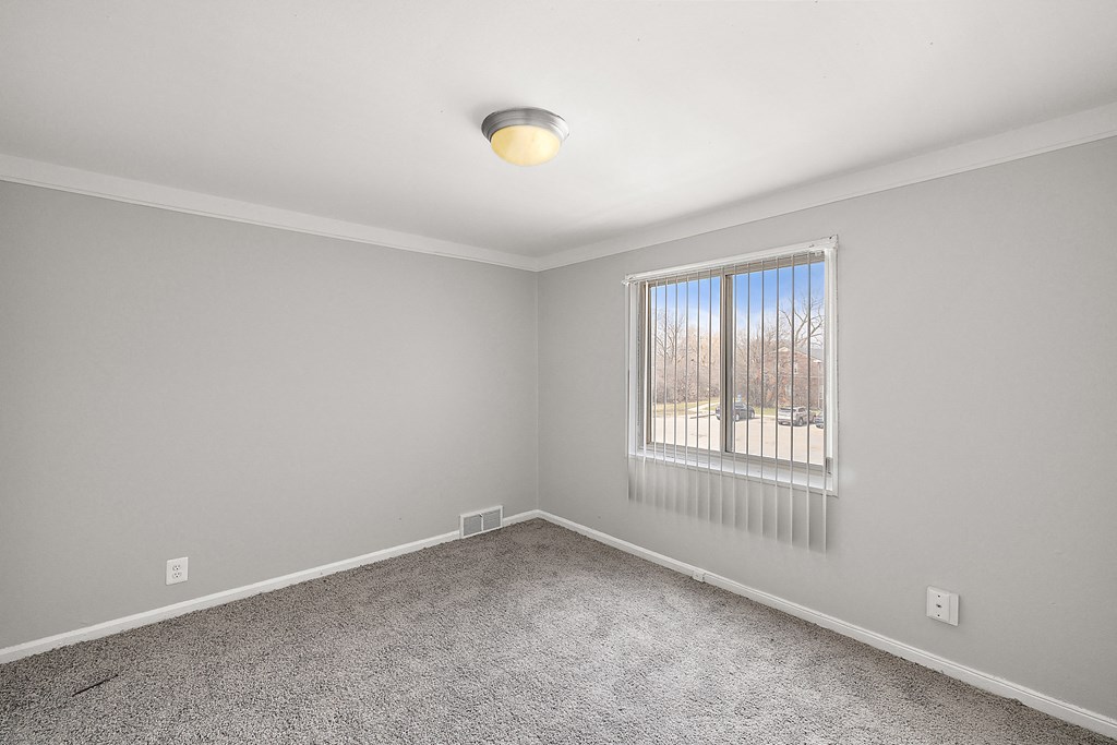a bedroom with gray walls and a large window