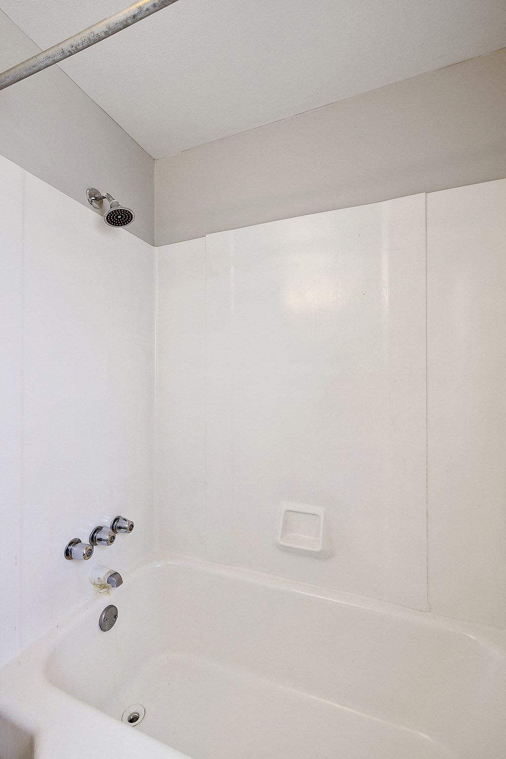 a small white bathroom with a shower and bathtub