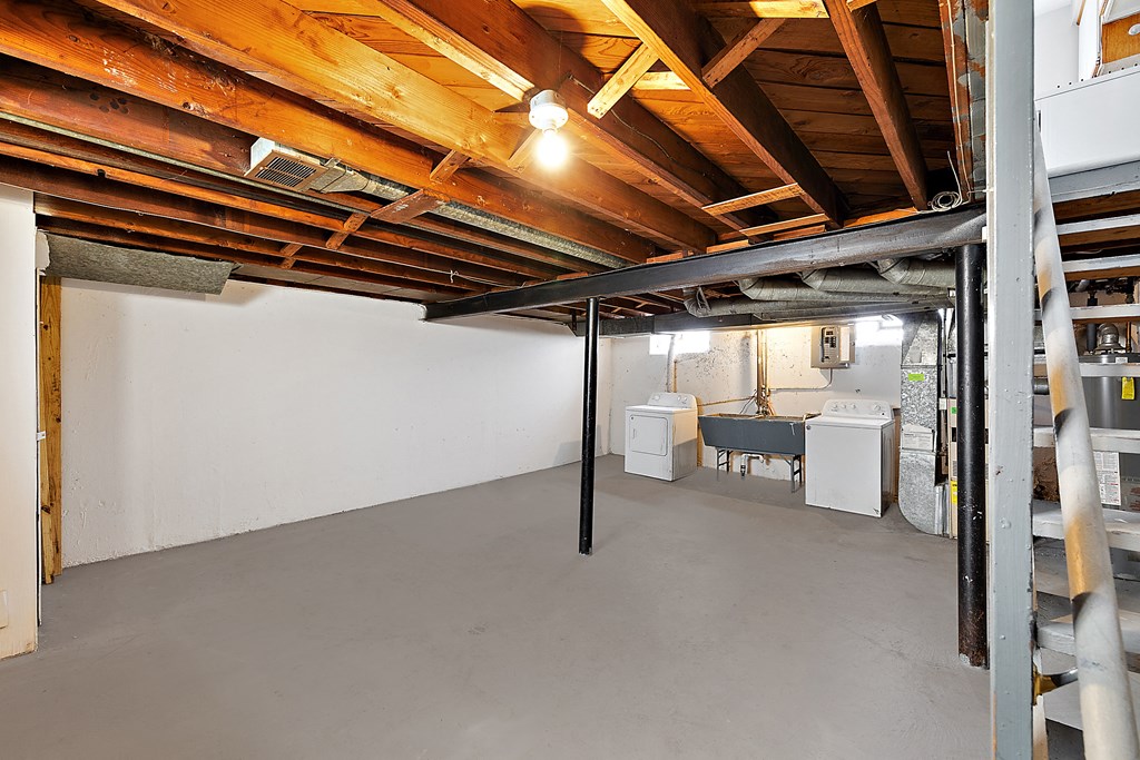 a basement with a sink and a laundry room