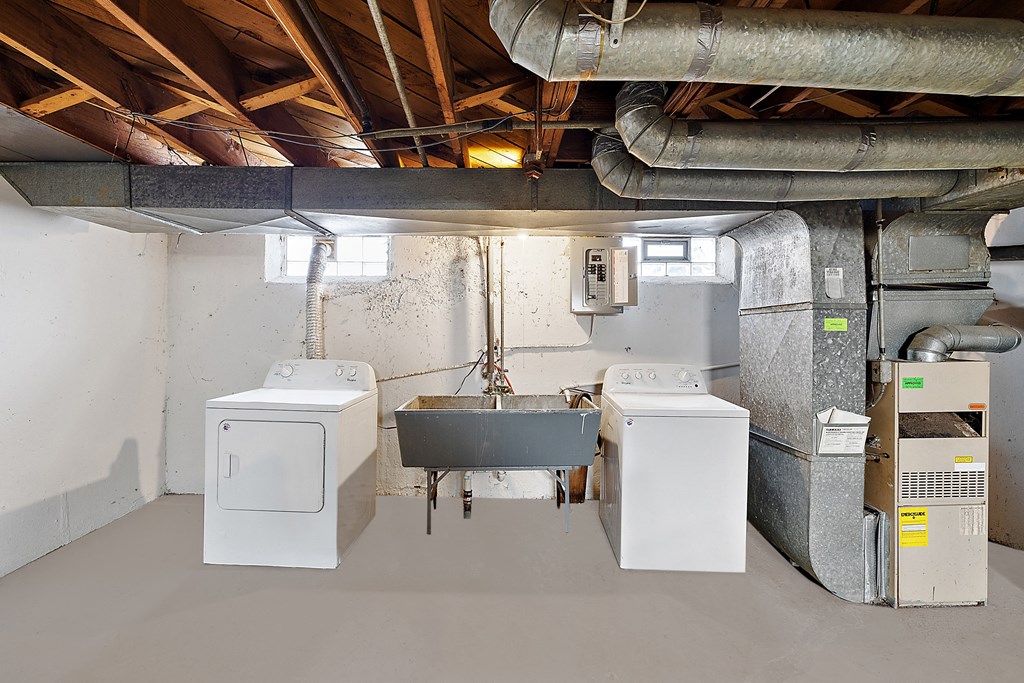 a laundry room with two washers and a sink