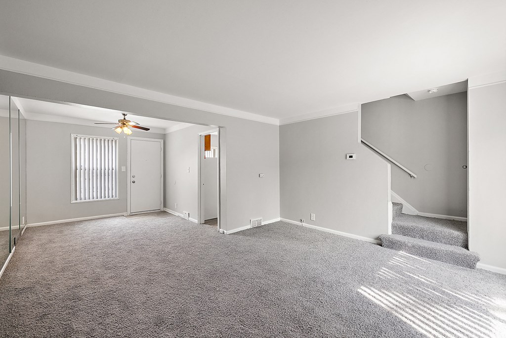 a bedroom with a medium sized bed and a staircase to the second floor