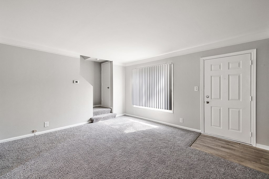 a bedroom with grey carpet and a white door