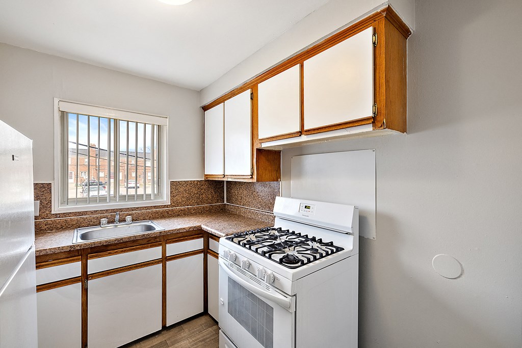 a kitchen with white cabinets and a white stove top oven