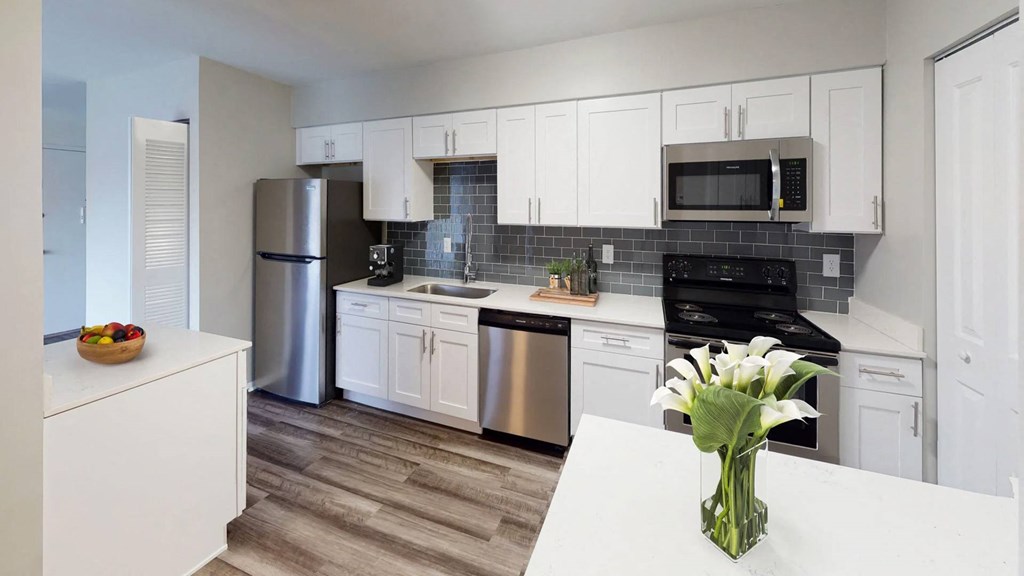 a kitchen with white cabinets and stainless steel appliances