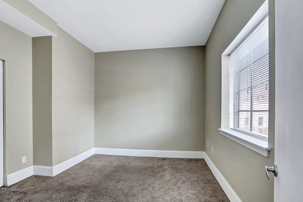 an empty room with carpet and a window