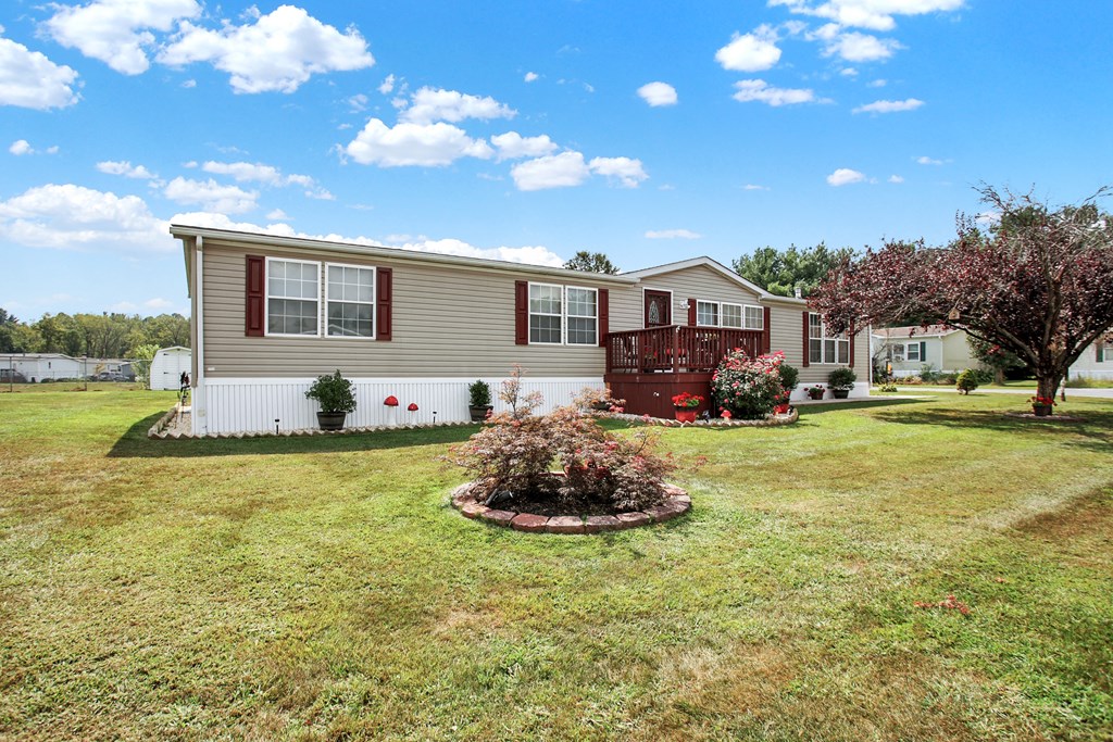 a home with a lawn and a tree in front of it
