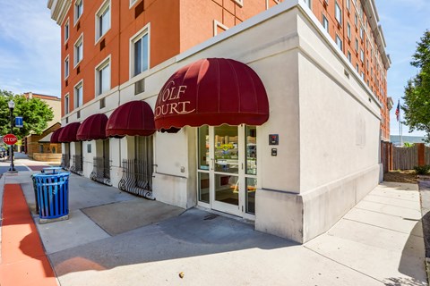 A white building with a red awning that says "OLF COURT".