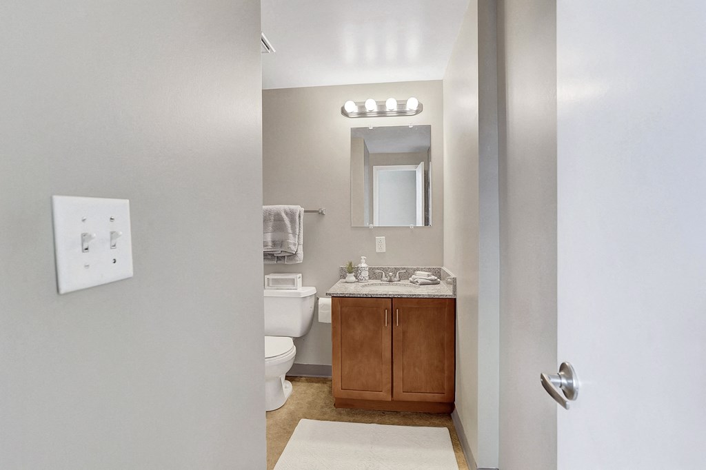 an open door to a bathroom with a toilet and sink