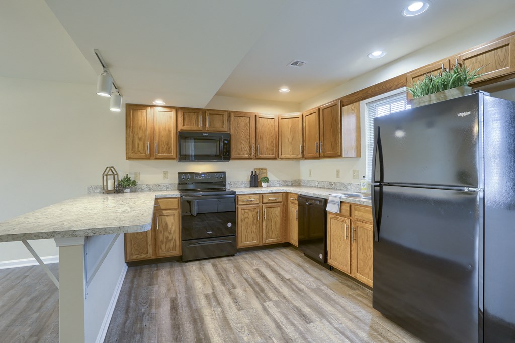Mechanicsburg Apartments | Rockledge Townhomes | a kitchen with wooden cabinets and black appliances