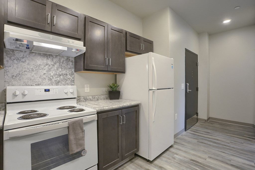 Mount Joy Senior Housing | a kitchen with dark cabinets and white appliances