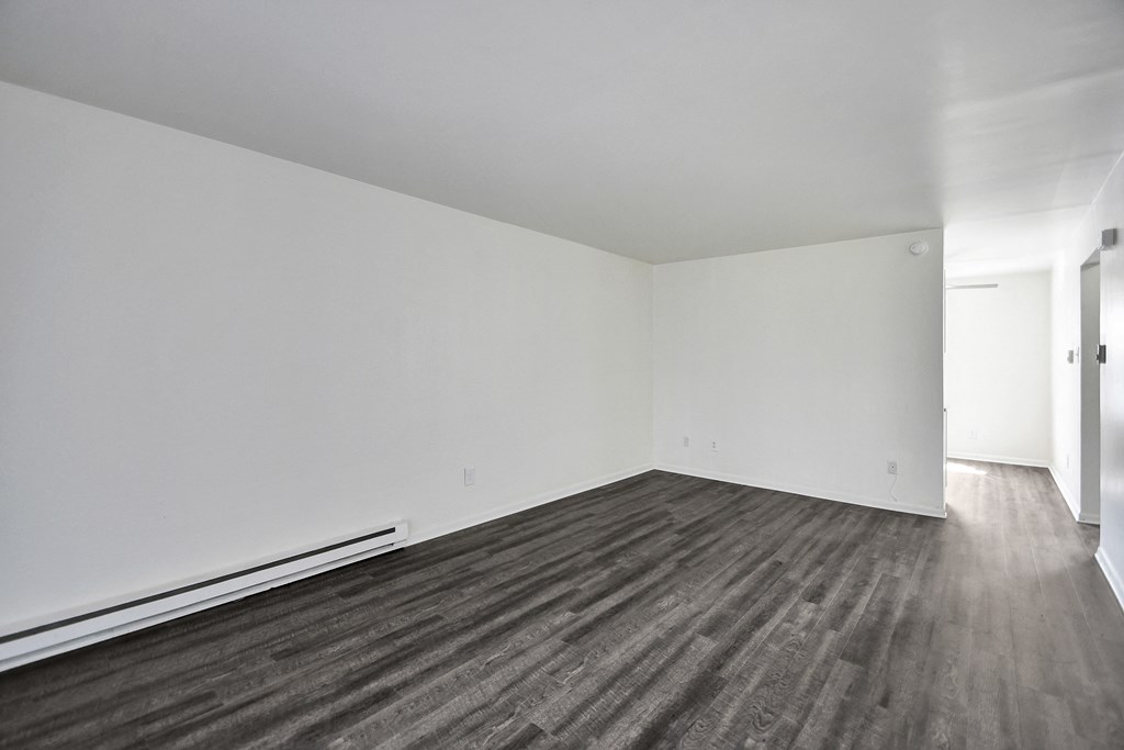 A room with a wooden floor and white walls.