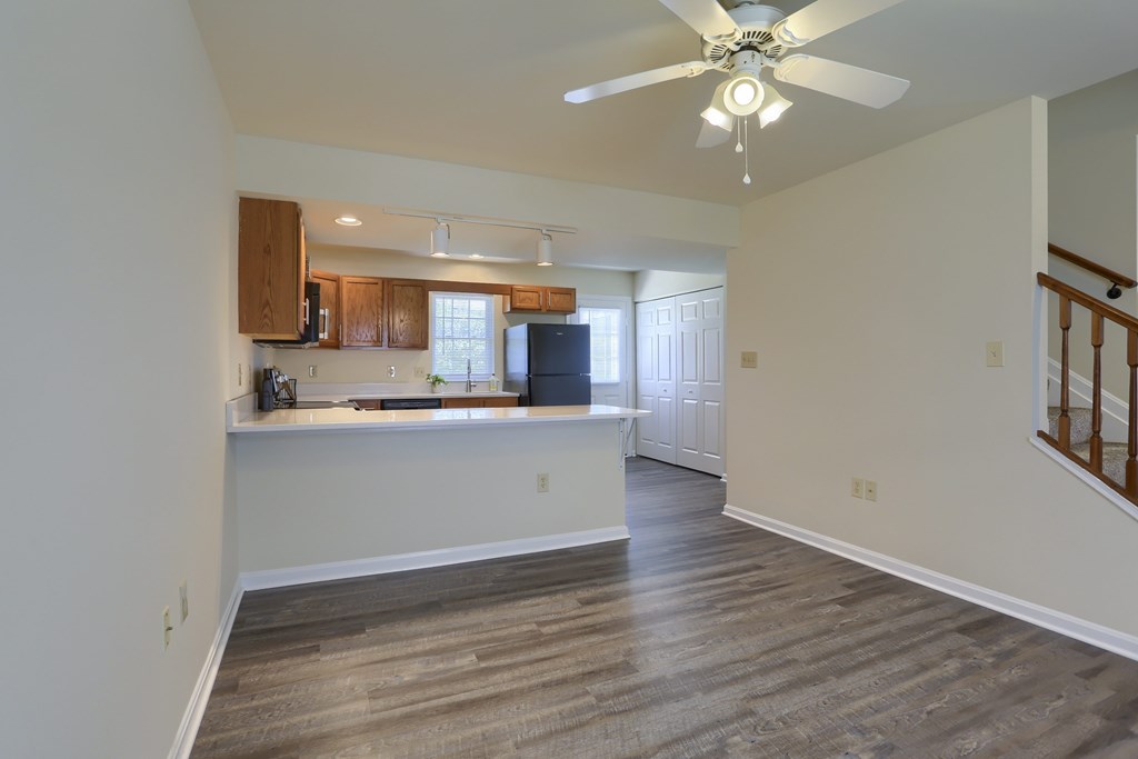 A room with a ceiling fan and wooden flooring.