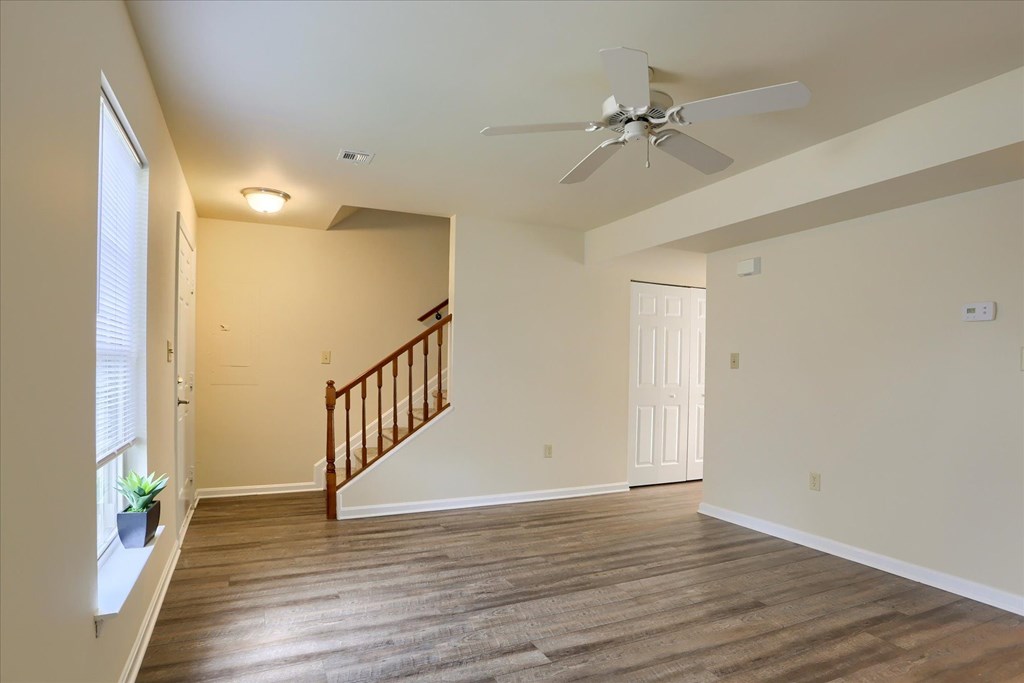 A room with a wooden floor and a ceiling fan.