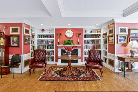 A living room with a red and white color scheme and a large clock on the wall.