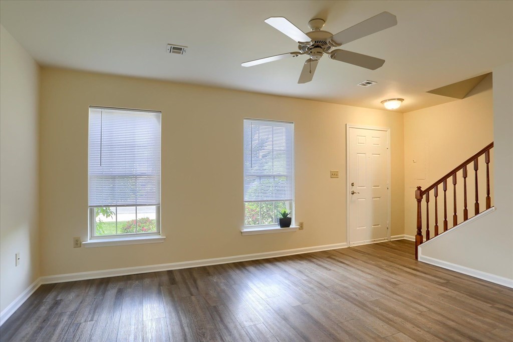 A room with a staircase and a ceiling fan.